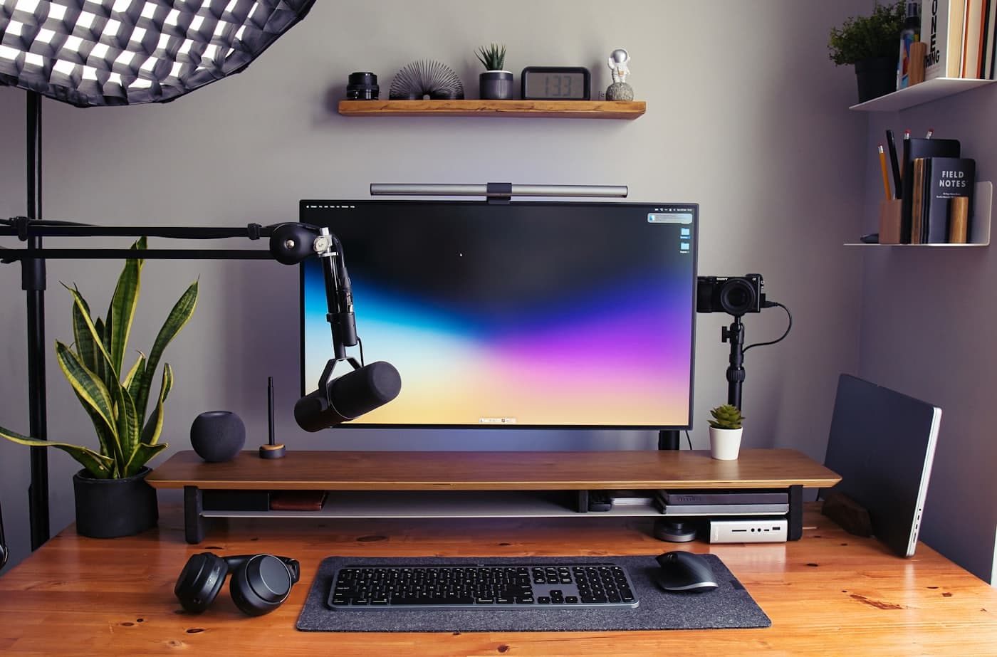 A tidy desk with a monitor, keyboard and headphones